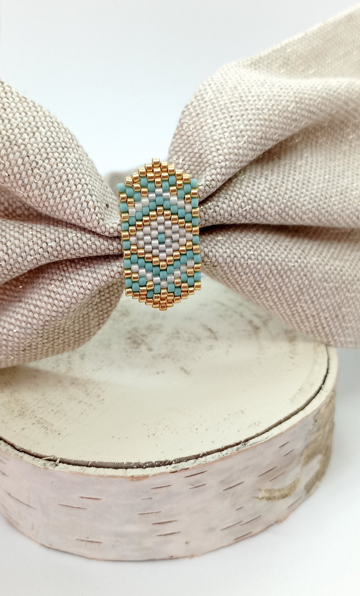 bandeau et tissu beige dorée et broche en perles tissées bleue, blanche et doré sur rond de bois 